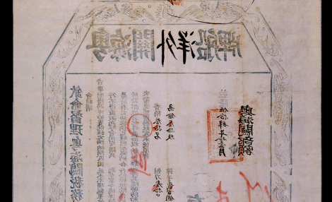 hexagonal stamp printed on aged paper and featuring Mandarin Chinese symbols in Black ink with a border or dragons. Red marks also appear on the page.